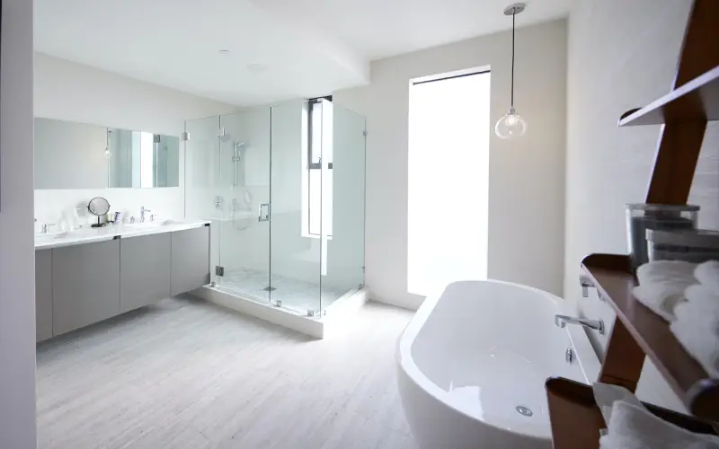 Modern domestic bathroom with shower cabin and freestanding bath, sunlight, no people