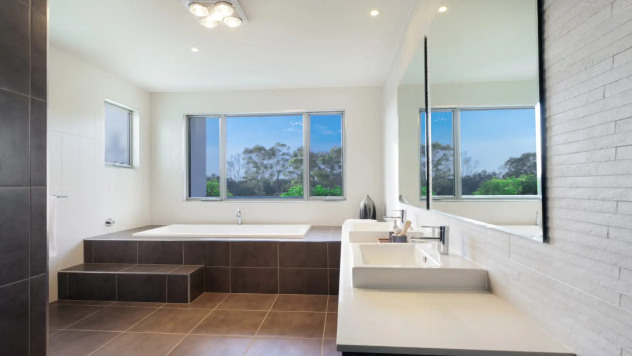 Modern bathroom remodeling in South King County with large windows, sleek tiles, and spacious vanity area.