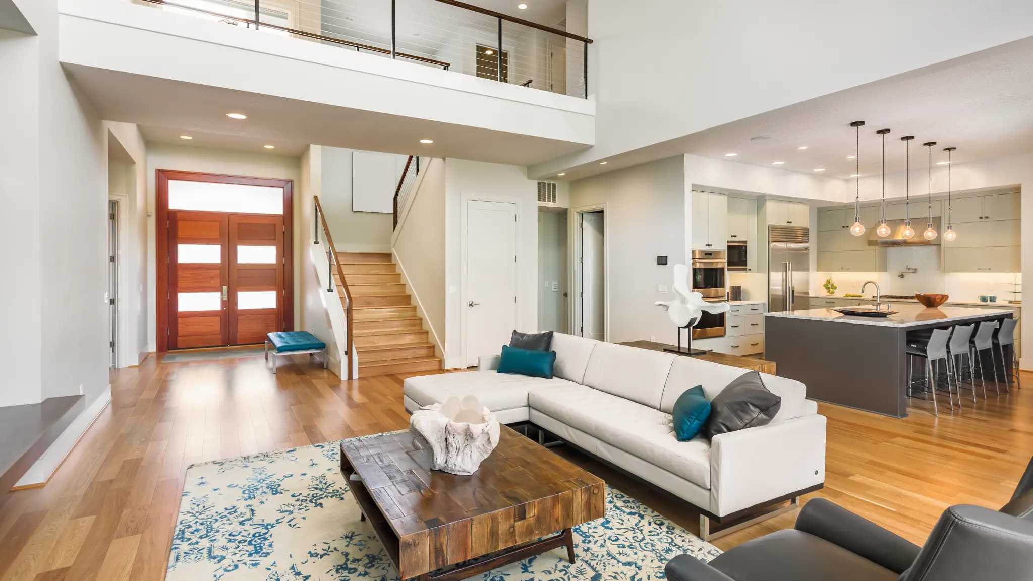 Bright open-concept layout after general remodeling in South King County featuring wood floors and modern lighting.