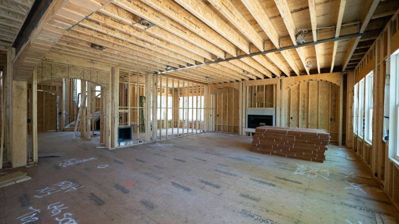 Interior framing of a custom-built home under construction, highlighting open layout and wood framing in progress.