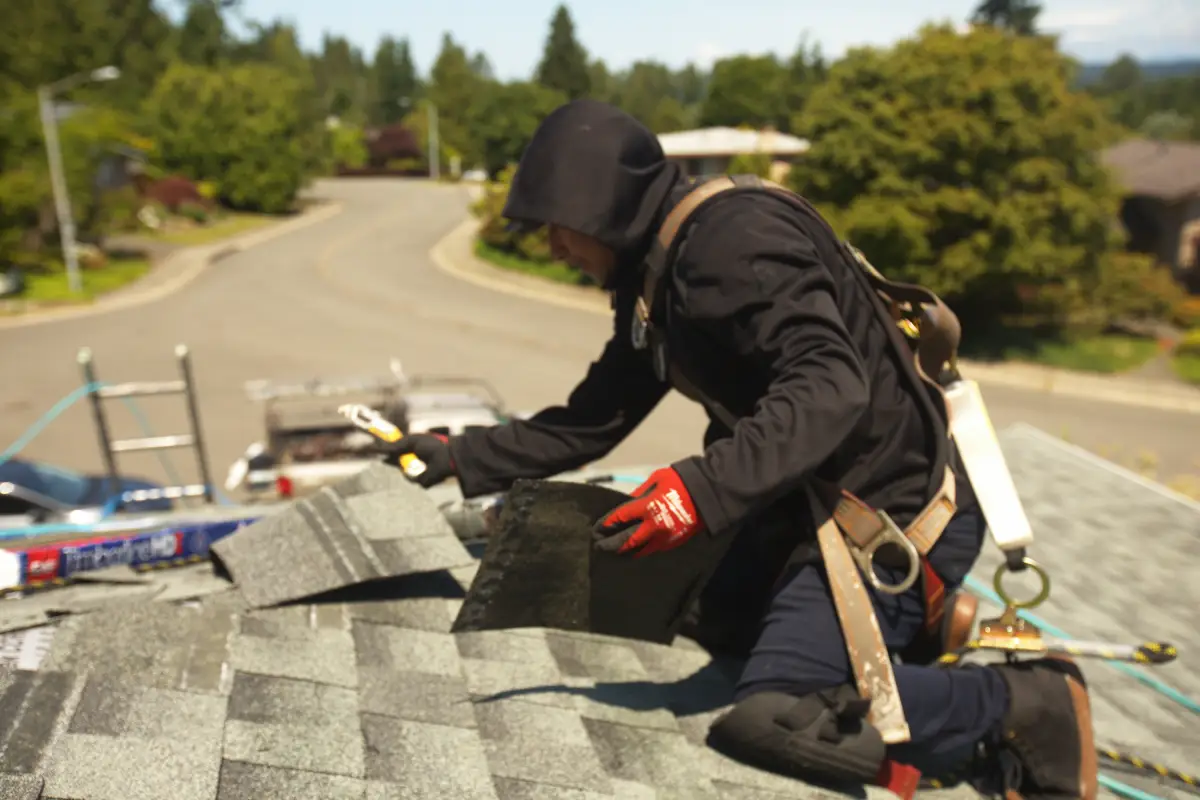 Roofing contractor installing shingles on a sunny day, showing a reliable roofing service near me for local homeowners.